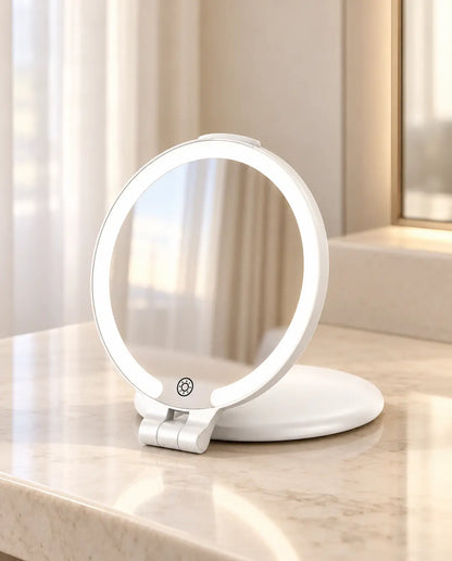 White round folding LED makeup mirror with a solid white base on a cream vanity.