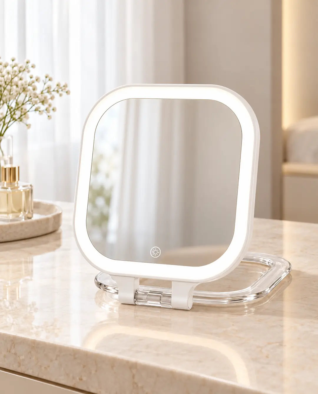 White rounded-square folding LED travel mirror with a transparent base on a cream dressing table.
