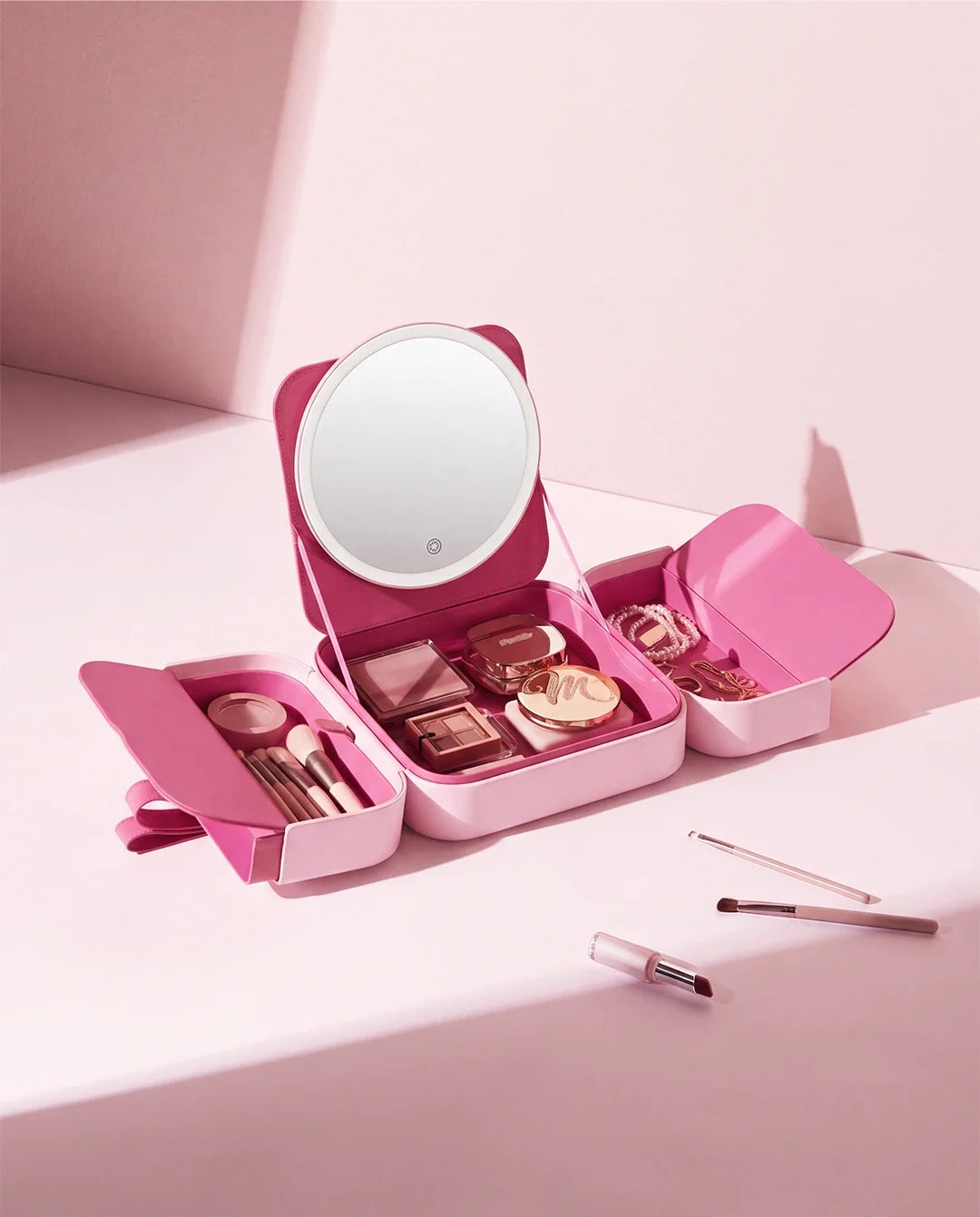 Pink makeup organizer case with LED mirror and multiple compartments for cosmetics, brushes and beauty accessories.