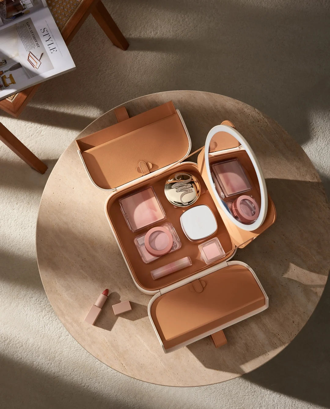 Beige travel makeup case with LED mirror and organized compartments for cosmetics, brushes and beauty essentials.